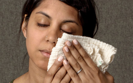 Image of a woman holding a washcloth to her cheek