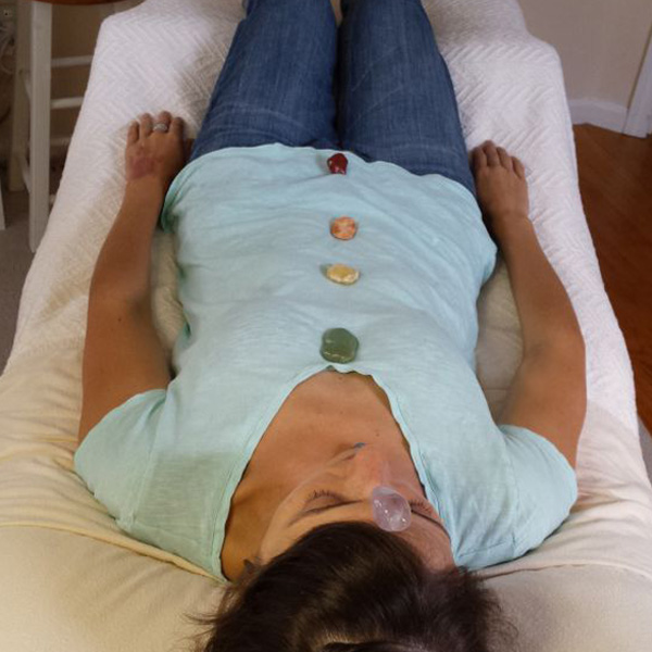 Photo of women lying with chakra crystals on her body
