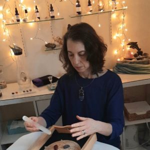 Photo of Saralee in her treatment room with a grid and doing a Distance Crystal Energy Healing