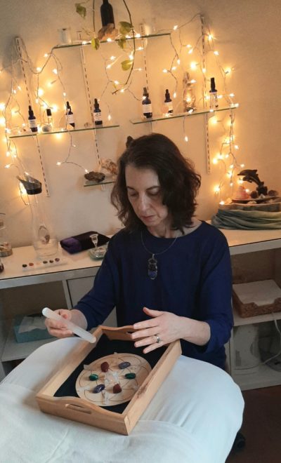 Photo of Saralee in her treatment room with a grid and doing a Distance Crystal Energy Healing
