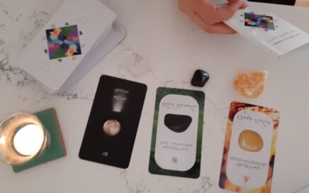 Photo of 3 tarot cards with crystals and a candle