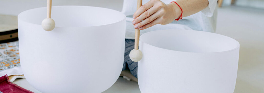 Two white crystal singing bowls.